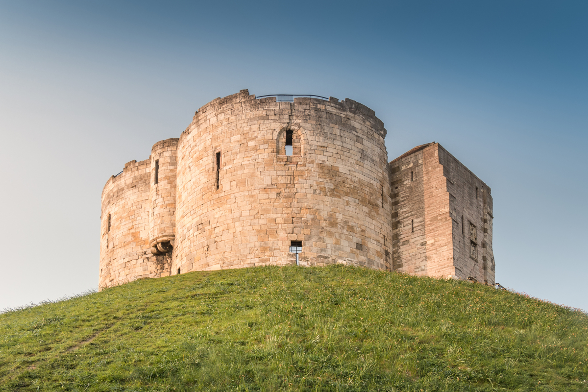 Clifford's Tower, erected by William the Conqueror, marks York's historical evolution from the Viking era Jórvík to its strategic importance in Norman England.